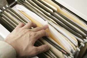 lawyer going through filing cabinet for legal documents