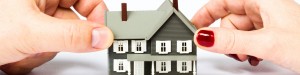 Hands holding onto miniature house
