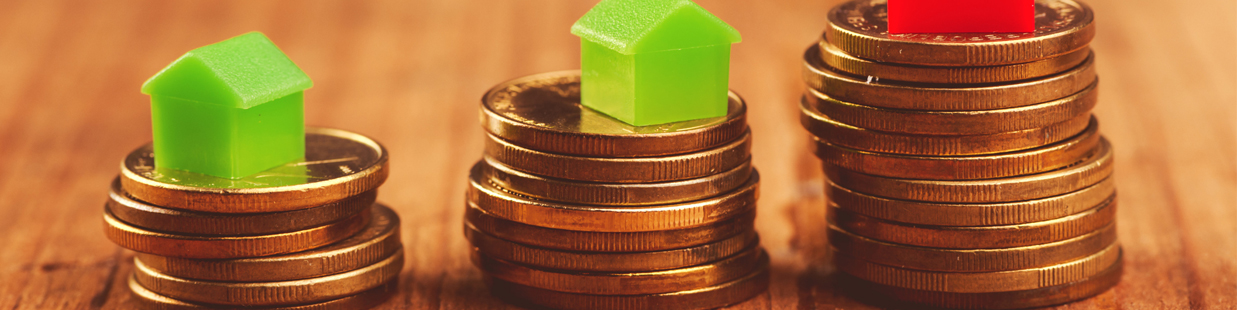 tiny houses on top of stack of coins representing household-income